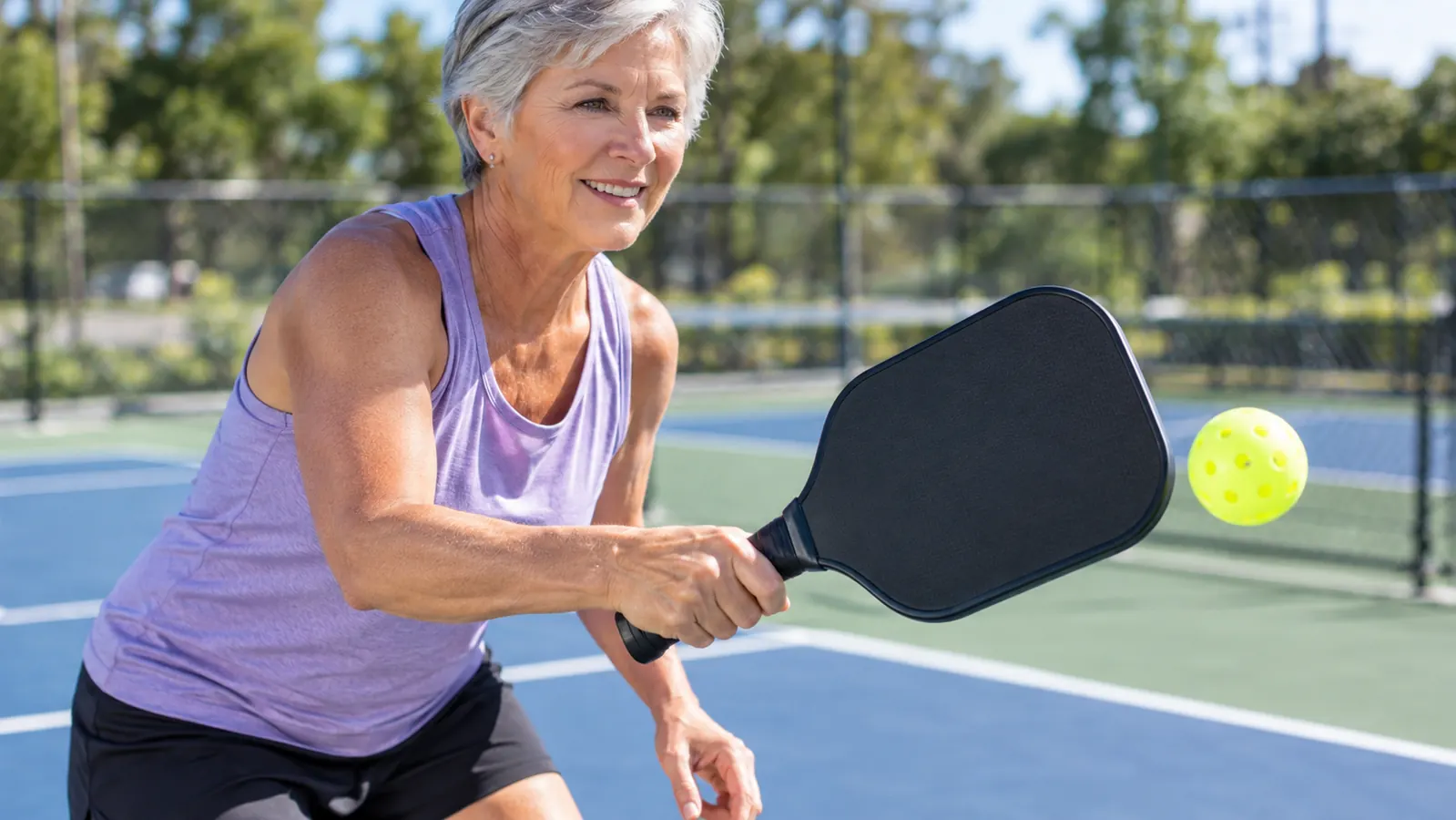 A player's hand gripping a paddle with a cushioned overgrip during a game